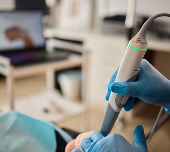 Gloved hands holding an intraoral camera