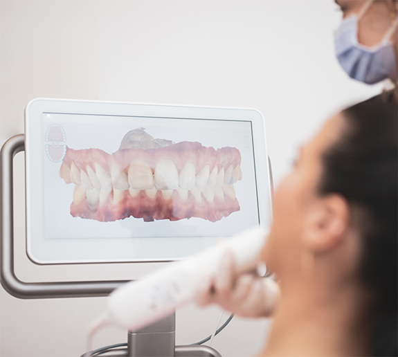 Patient looking at monitor displaying digital impression of teeth