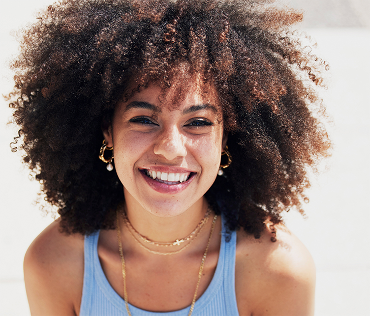 Woman with curly hair showing off her smile