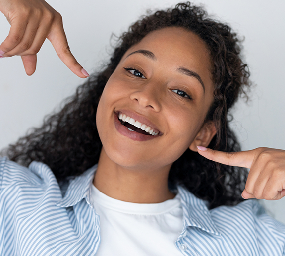 Smiling woman pointing to her teeth