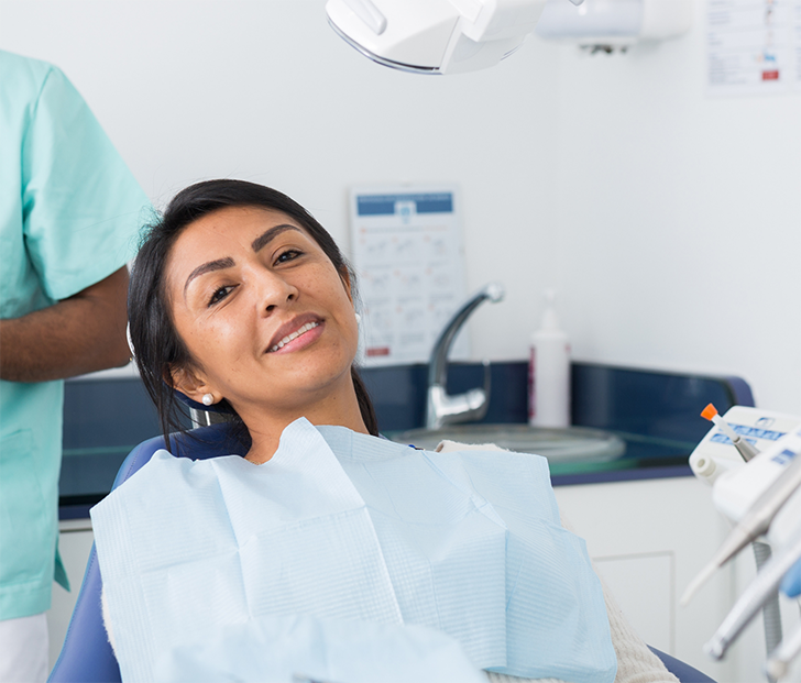 Female patient sitting in dental chair and smiling