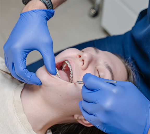 Patient with braces having teeth examined