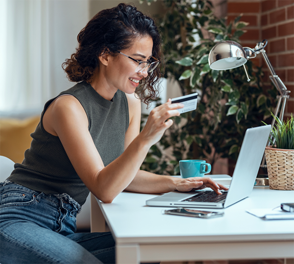 Woman typing on laptop and using credit card