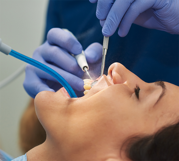 Woman having teeth cleaned by dentist