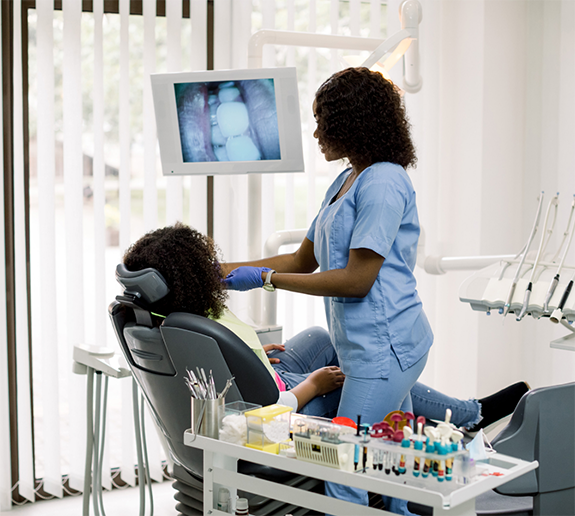 Dentist using intraoral camera to examine patient's teeth
