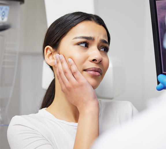 Close up of woman rubbing her jaw in pain